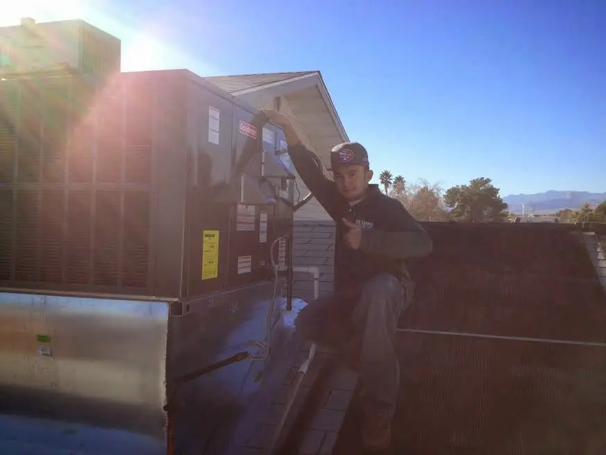 HVAC technician performing HVAC Inspection on a rooftop unit in Totowa